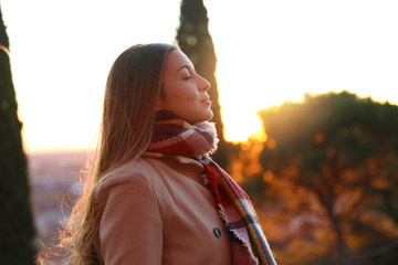 Portrait of a girl breathing fresh air wearing jacket at sunset