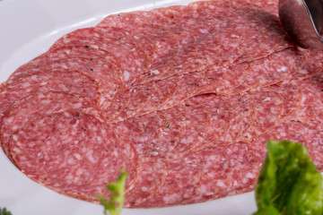 Portion sausage on a plate of greens