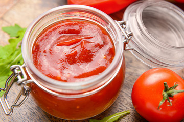 Jar with tasty barbecue sauce on table