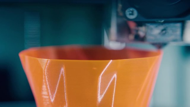 Modern printer shaping a form with plastic in a 3d printing lab.