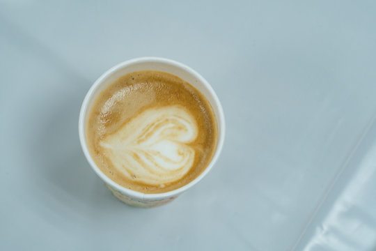 Top Down Close Up View Of Heart Shaped Latte Art Cappuccino Coffee In Paper Cup Isolated On White