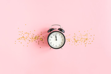 Black alarm clock and gold stars confetti on pink background. Concept Insomnia, sleep problems or sweet dreams and good night. Top view Flat lay Copy space