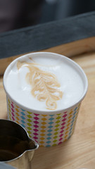 Close up view of paper cup with latter art drawing.