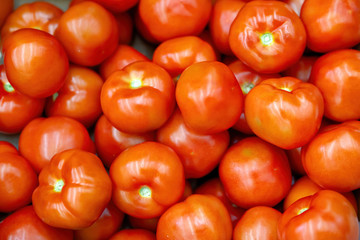 Vegetables are full of vitamins. Fresh and ripe tomatoes in a basket on a supermarket shelf