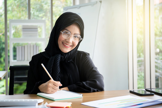 Portrait of smart beautiful Asian Muslim businesswoman working in the office, Diversity cultural and gender concept.