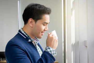 Portrait of smart and handsome young businessman drinking a coffee