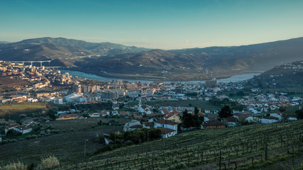 Obraz premium Evening panorama of the city of Regua on the banks of the Douro River among the grape hills in Portugal