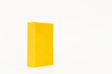 Yellow car washing sponge close up on white background.