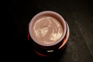 close up jar of light pink face cream