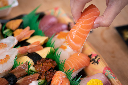 Hand holding sushi, assorted sushi sold at supermarkets.