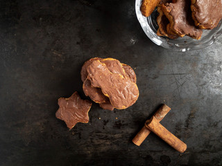 Chocolate cookies with different shapes on dark rustic background.
