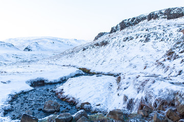 Fototapeta na wymiar Incredible winter landscape of Iceland. In winter, a source of hot water flows in the mountains