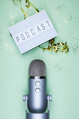 Vertival top view shot of professional silver microphone for podcasting with lightbox with word...