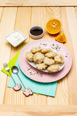 Fish dumplings. The concept of healthy food for children. Sour cream, soy sauce, cutlery. Wood background