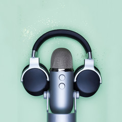 Microphon and headphones on mint table with gold glitter - top view photo of professional podcast...