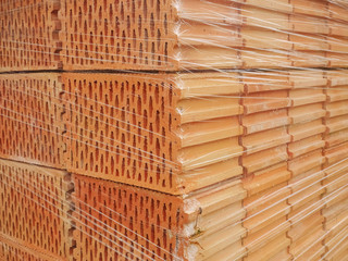 Orange bricks wrapped in plastic wrap. Construction material.
