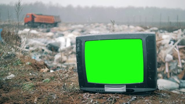 Garbage dump with a broken TV in the snow