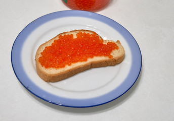 sandwich with red caviar lies on a plate