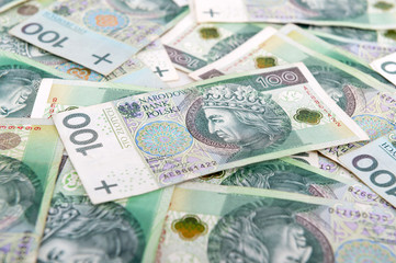 Obraz na płótnie Canvas Polish zloty background. Pile of Polish 100 zloty (PLN) banknotes lying flat. Republic of Poland currency