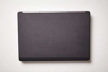 Fototapeta premium Modern laptop computer on white background with shadow. Top view, close up.
