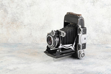 Old medium format rangefinder camera on gray cement background.