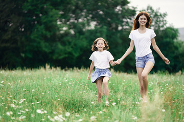 Fototapeta premium mother and daughter running in the park