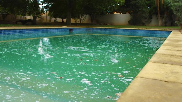 A Filthy Swimming Pool Filled With Shock Powder - Wide Shot