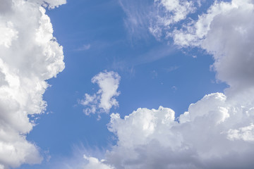 background of white fluffy clouds on a bright blue sky