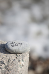 Words on pebble stones – motivational concept slogan – word joy