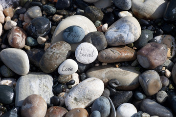 Words on pebble stones – motivational concept slogan – words love, travel, enjoy