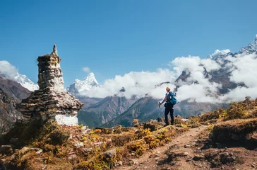 Cercles muraux Ama Dablam Young hiker backpacker man with trekking poles enjoying the Ama Dablam 6814m peak mountain during acclimatization walk near buddhist stupa.Everest Base Camp route,Nepal. Active vacations concept image