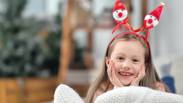 Portrait of little baby girl posing in funny Christmas ears laughing having positive emotion