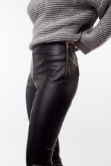 Close-up of black leather pants and hand