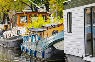 Fototapeta na wymiar Houseboats lined up in a canal in Amsterdam in the autumn. 