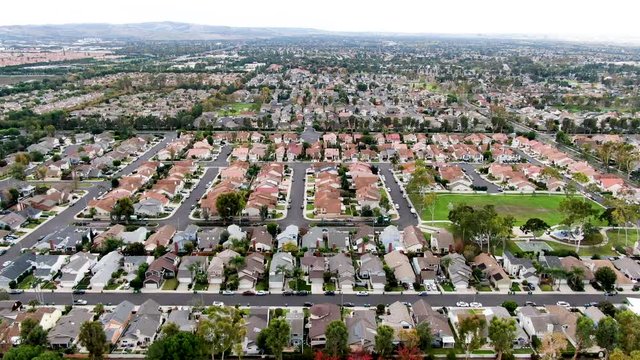Aerial view of urban sprawl. Suburban packed homes neighborhood with road. Vast subdivision in Irvine, California, USA