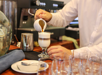 Barista making a creamy coffee drink.