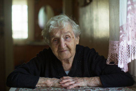 Home portrait of an elderly gray-haired granny woman.