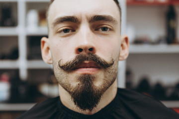 portrait of a satisfied barber shop customer who came to change his beard shape