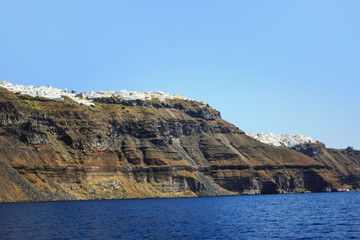 Fototapeta na wymiar The coast of the Greek island of Santorini with the cliff towns of Oia and Thira