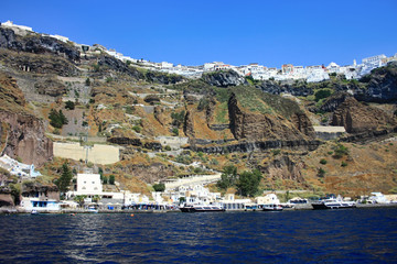 Fototapeta na wymiar The coast of the Greek island of Santorini with the cliff towns of Oia and Thira