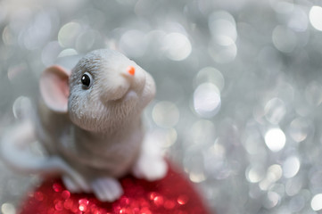 Toy mouse on a Christmas ball close-up on a background with bokeh. The year of the rat is 2020...