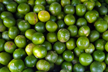 Many green lime fruits on fresh market. Top view.