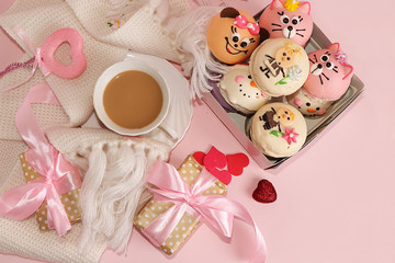 Greeting card for Valentine's Day or Women's Day with a cup of cocoa with marshmallows. Red hearts and gift box on a pink background, top view. Holiday greetings, modern woman concept, Hygge style.