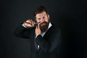 Manual shaving. Bearded man shave facial hair dark background. Businessman hold shaving tool....