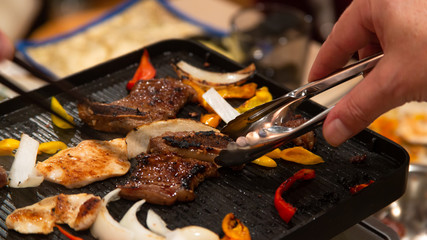 People grilling on an indoors electric grill
