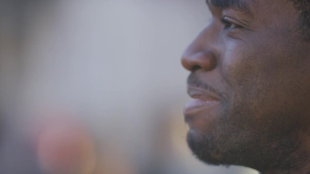 Profile shot of young black man engaged in humorous conversation with someone off screen