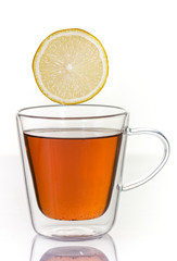 Tea with lemon in a glass thermo cup on a white background.