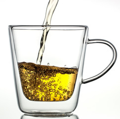 Glass transparent thermos cup with tea on a white background.