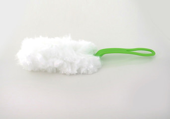 Microfiber duster with green handle isolated on white background.