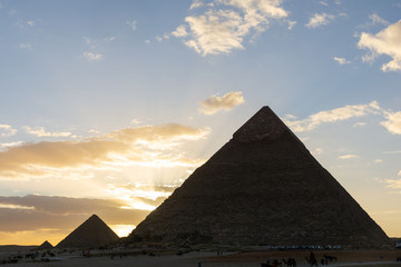Fototapeta na wymiar The Sun is going down behind the Pyramid of Menkaure